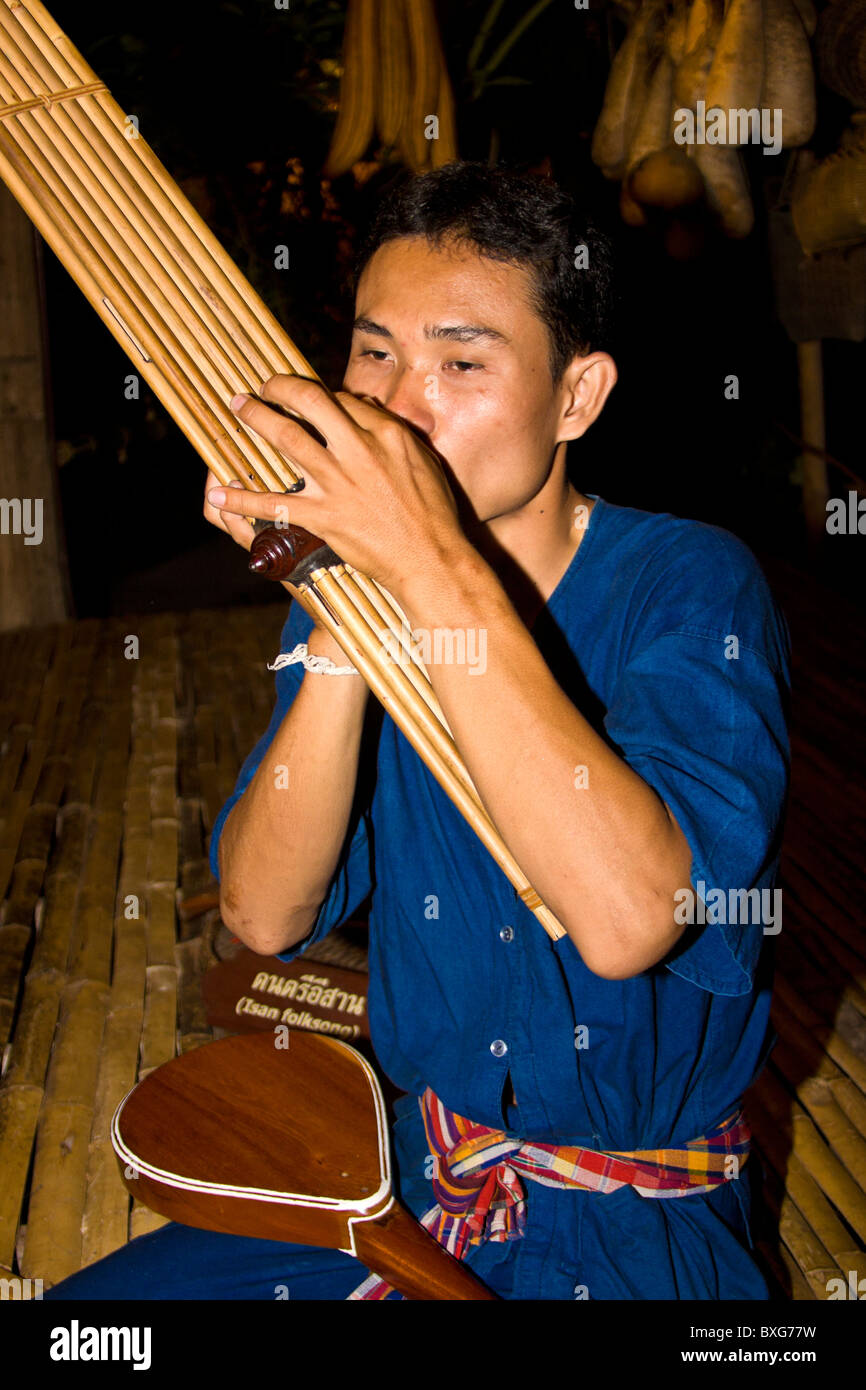 L'uomo gioca flauto tribali strumento. Colle persone della tribù del nord della Tailandia dimostrano i costumi e la cultura a Spettacolo Siam Niramit Foto Stock