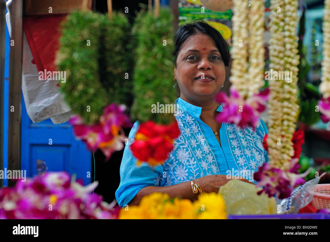 Signora indiana la vendita di ghirlande di fiori Singapore Foto Stock