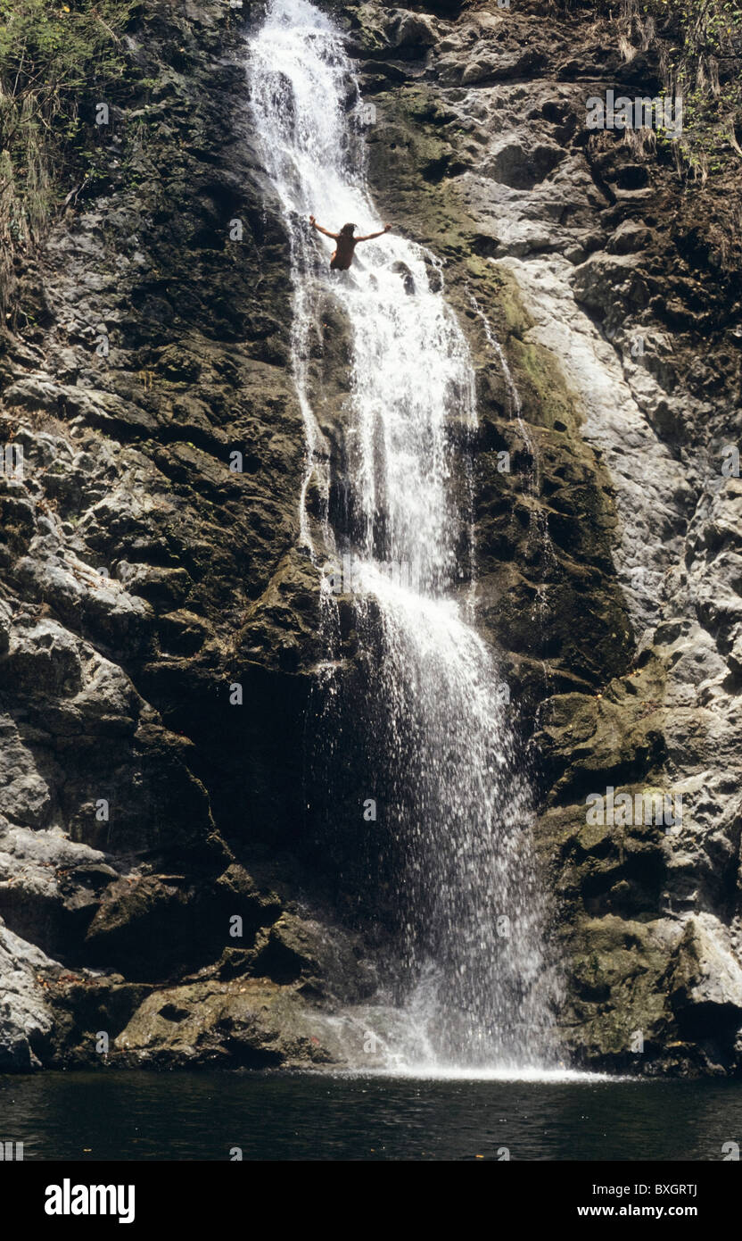 Costa Rica, Nicoya, Montezuma, Cascata, uomo saltando dalla scogliera in acqua Foto Stock