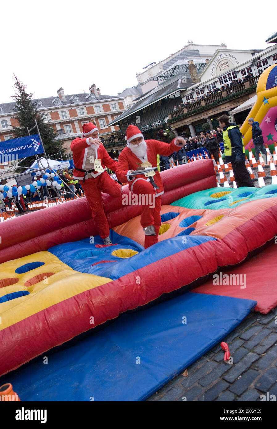 Due concorrenti vestiti come Santa, prendere parte al grande pudding natalizio gara, Covent Garden . Foto Stock