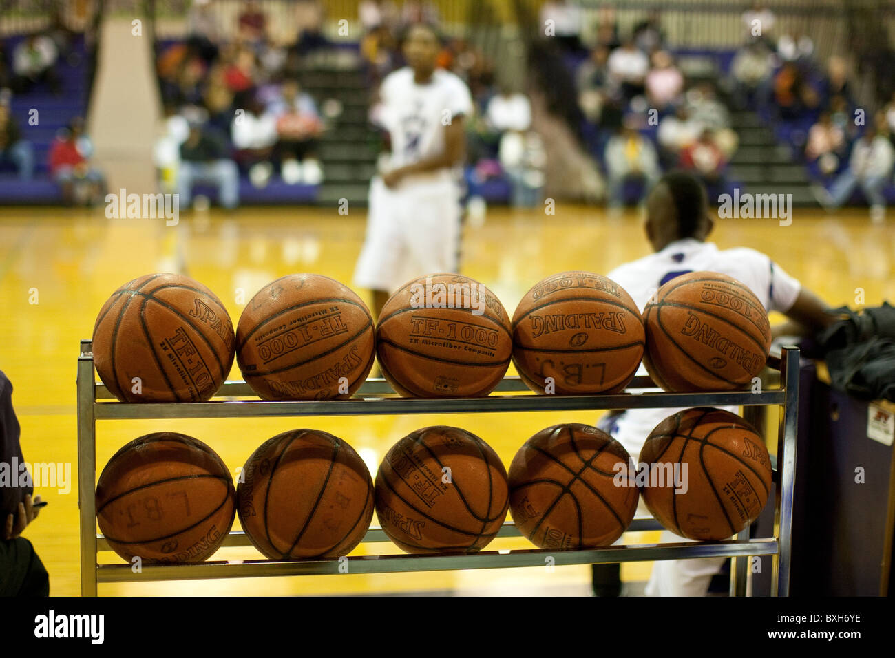 Basketballs allineate su un rack di rotolamento attendono utilizzare durante il warm-up presso una scuola di gioco di basket in Austin, Texas, Stati Uniti d'America Foto Stock