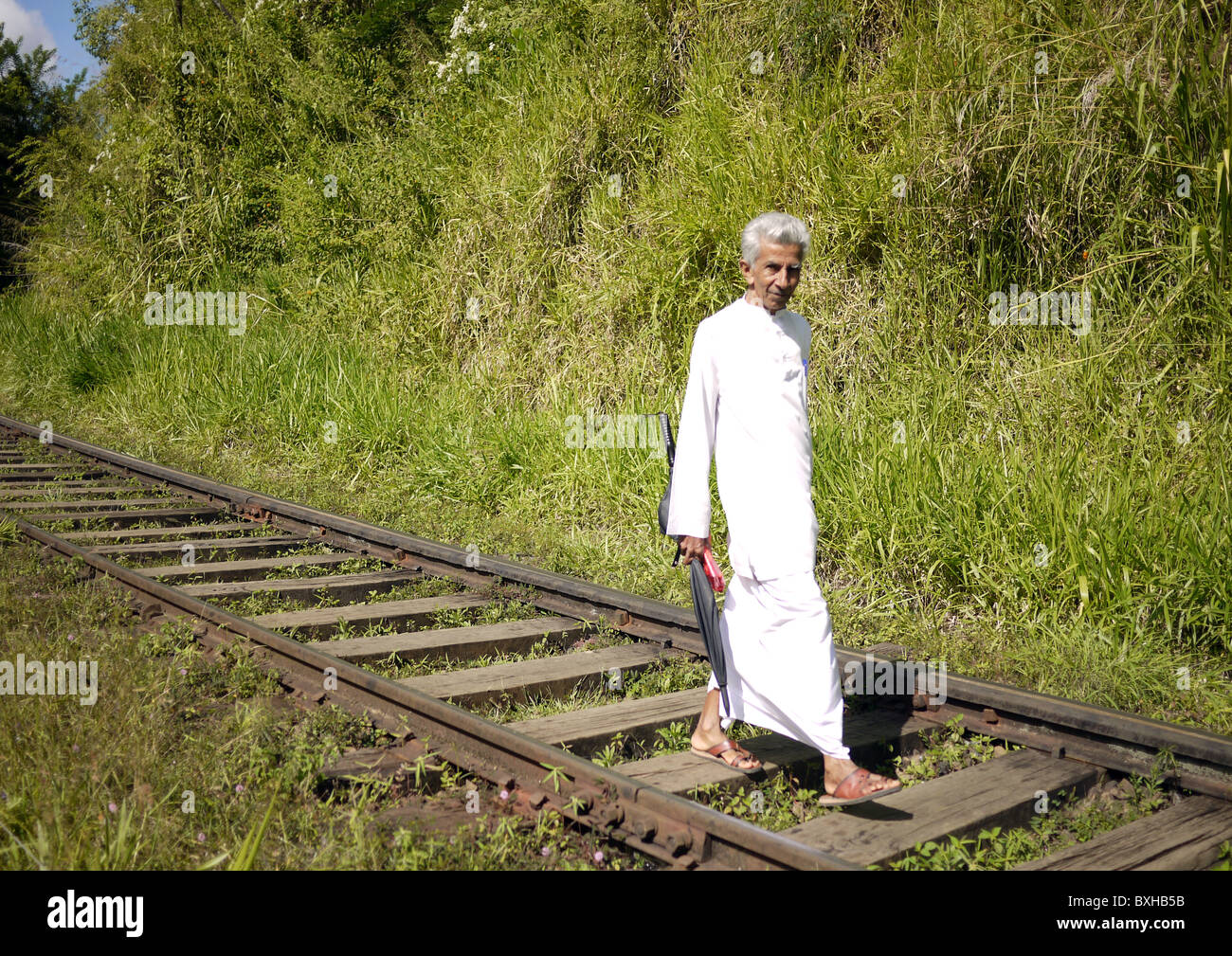 Uomo che cammina lungo la linea ferroviaria vicino a Ella, Sri Lanka Foto Stock