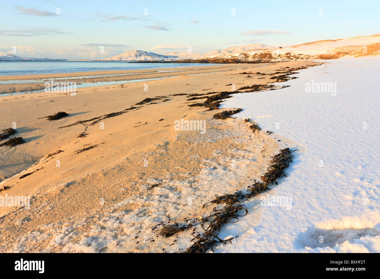Le alghe divide la sabbia dalla neve sulla spiaggia di Traigh Lar sull'Isle of Harris, Scozia Foto Stock
