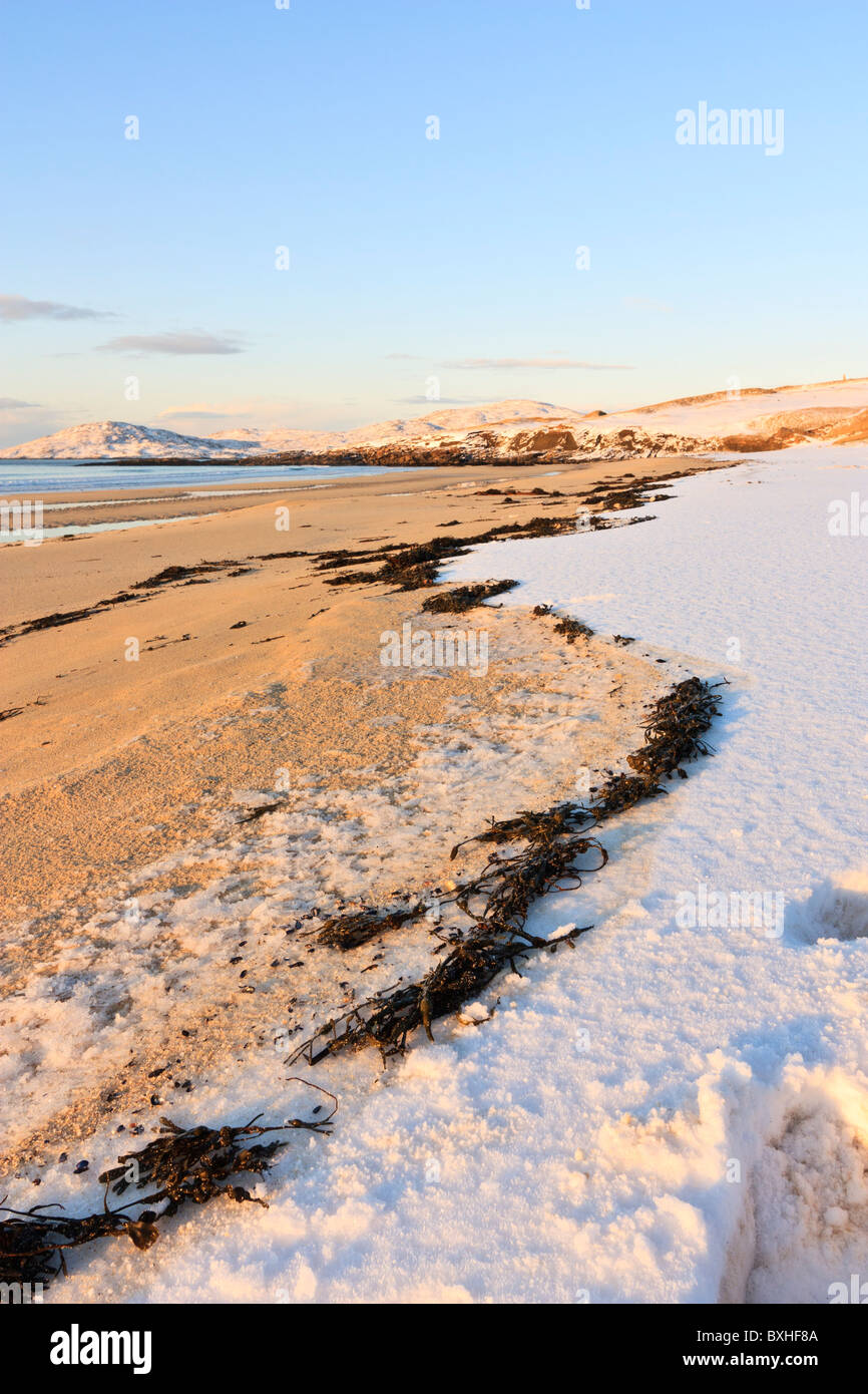 Le alghe divide la sabbia dalla neve sulla spiaggia di Traigh Lar sull'Isle of Harris, Scozia Foto Stock