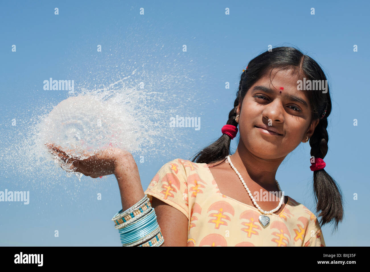 Ragazza indiana tenendo in mano un round burst palloncino dell'acqua. India Foto Stock