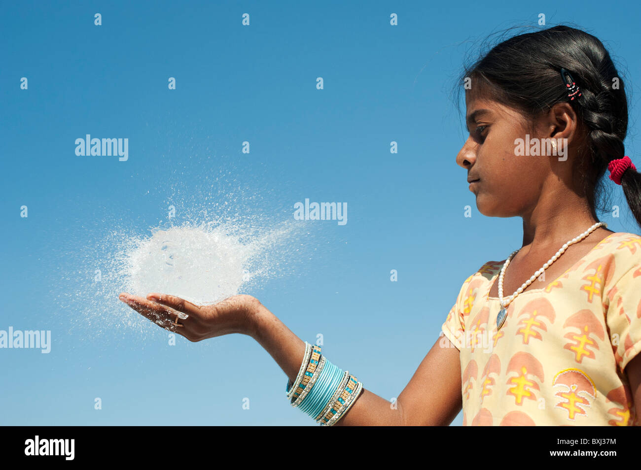 Ragazza indiana tenendo in mano un round burst palloncino dell'acqua. India Foto Stock