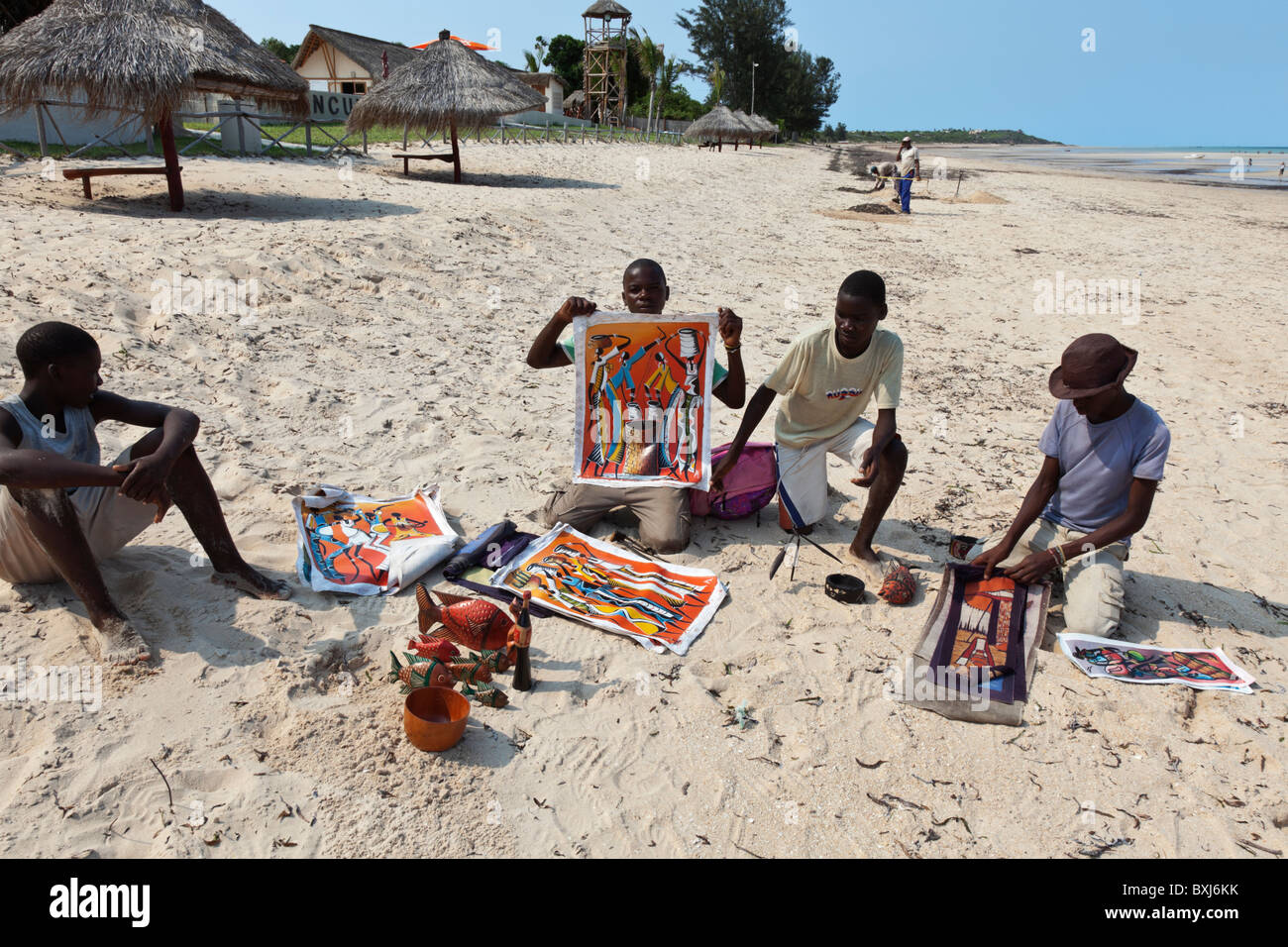 Quattro giovani africani venditori di curiosita' sulla spiaggia al di fuori di un villaggio turistico a Vilanculos Mozambico. Foto Stock
