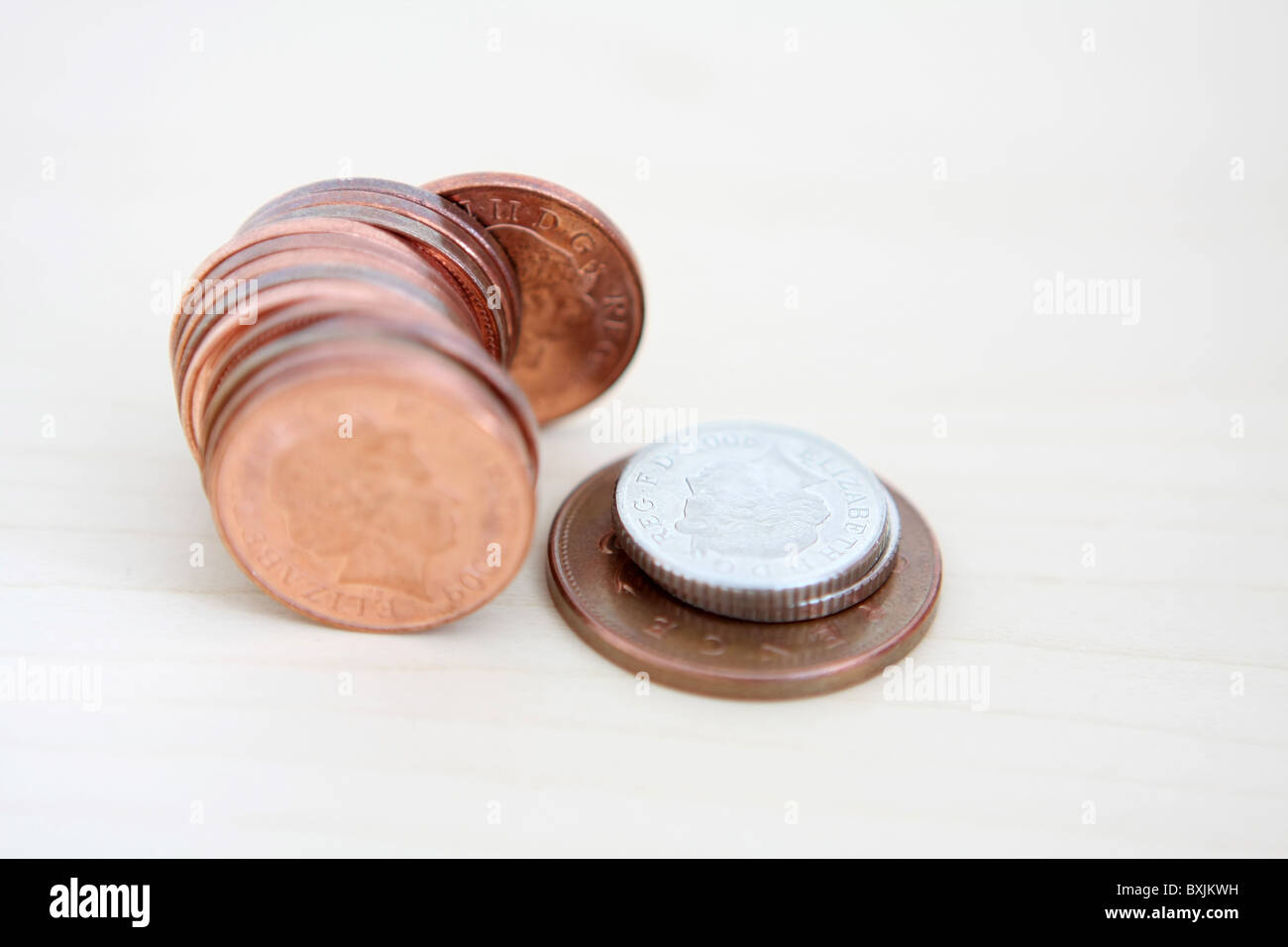 Una fila di sterling 1p monete accanto a 2 5p monete su un 2p coin Foto Stock
