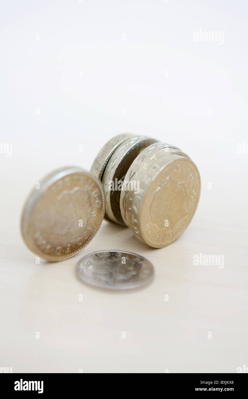 Sterling £1 monete sulle estremità e un 5p coin che giace piatto Foto Stock