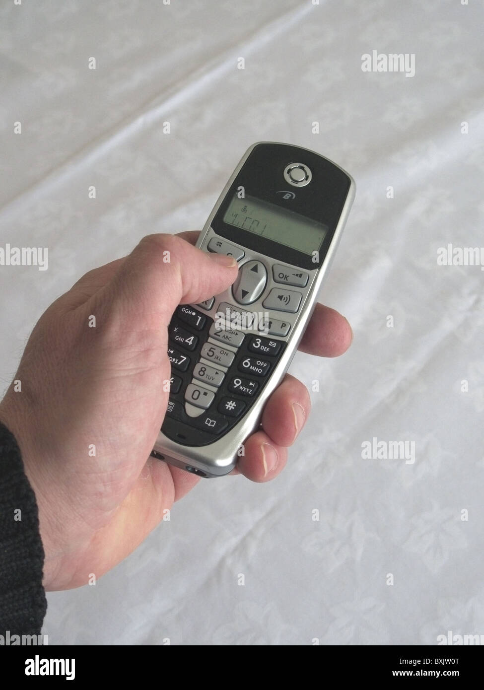 L'uomo la composizione di un numero su un Binatone Telefono Cordless modello rilasciato Foto Stock L'uomo la composizione di un numero su un Binatone Telefono Cordless modello rilasciato Foto Stock