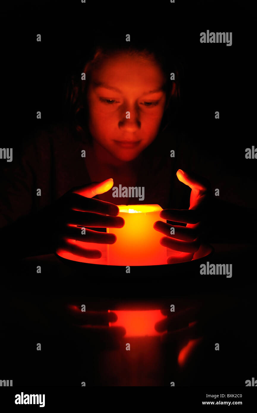 Ragazza cerca in una candela in earth hour. Foto Stock