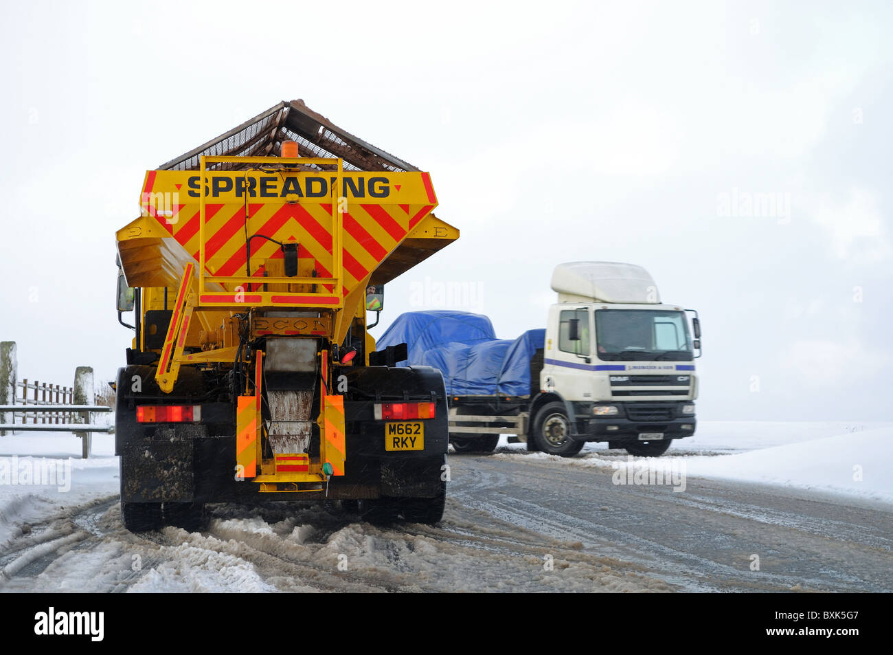 Un carrello gritting contribuendo a liberare un camion bloccati nella neve su Bodmin Moor, Cornwall, Regno Unito Foto Stock