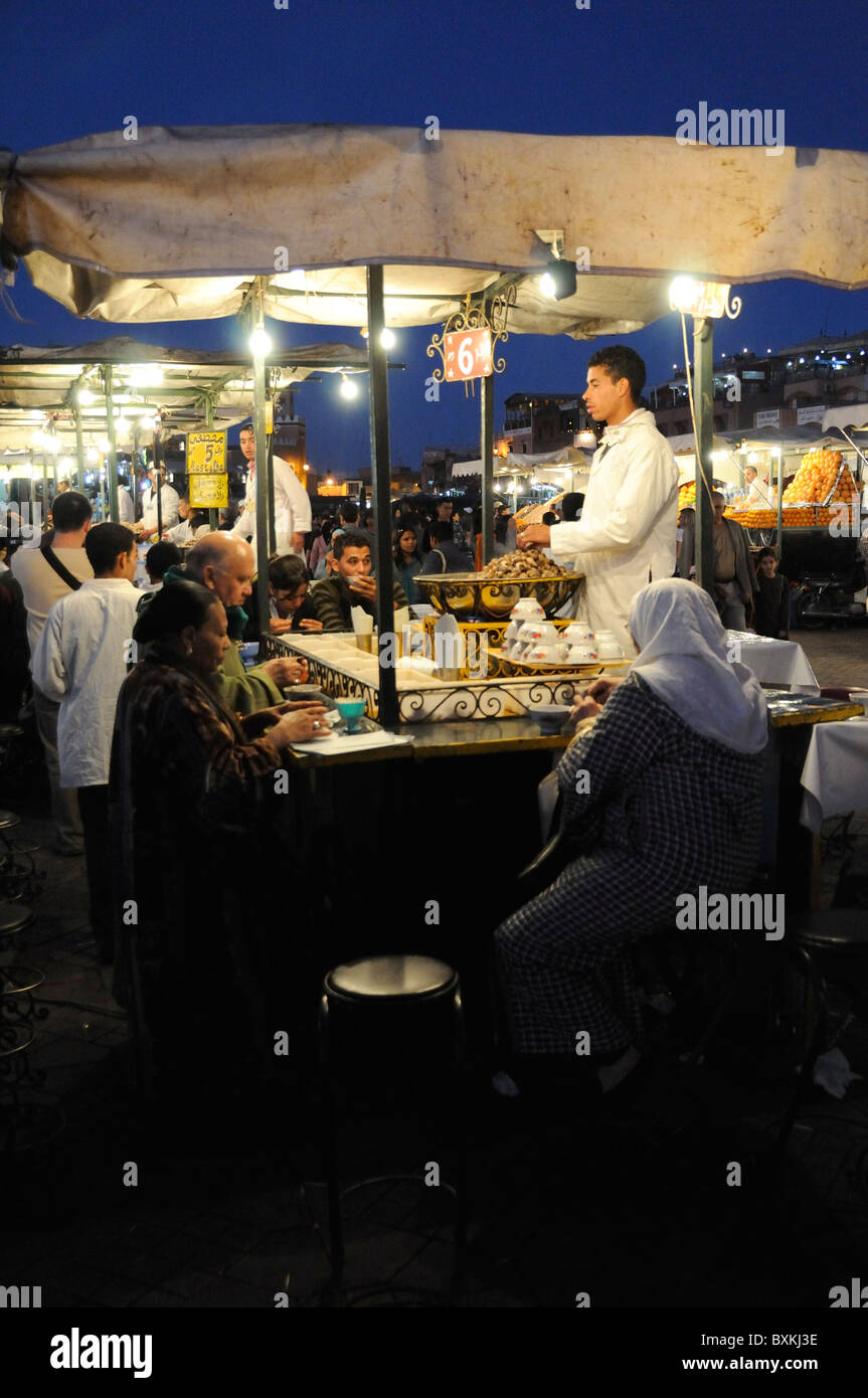 Diners a foodstalls a occupato Djemaa el Fna luogo di incontro di Marrakech Foto Stock