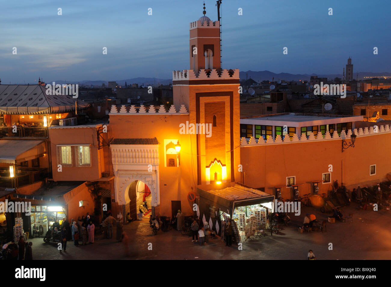 Moschea e occupato Djemaa el Fna luogo di incontro di notte a Marrakech Foto Stock