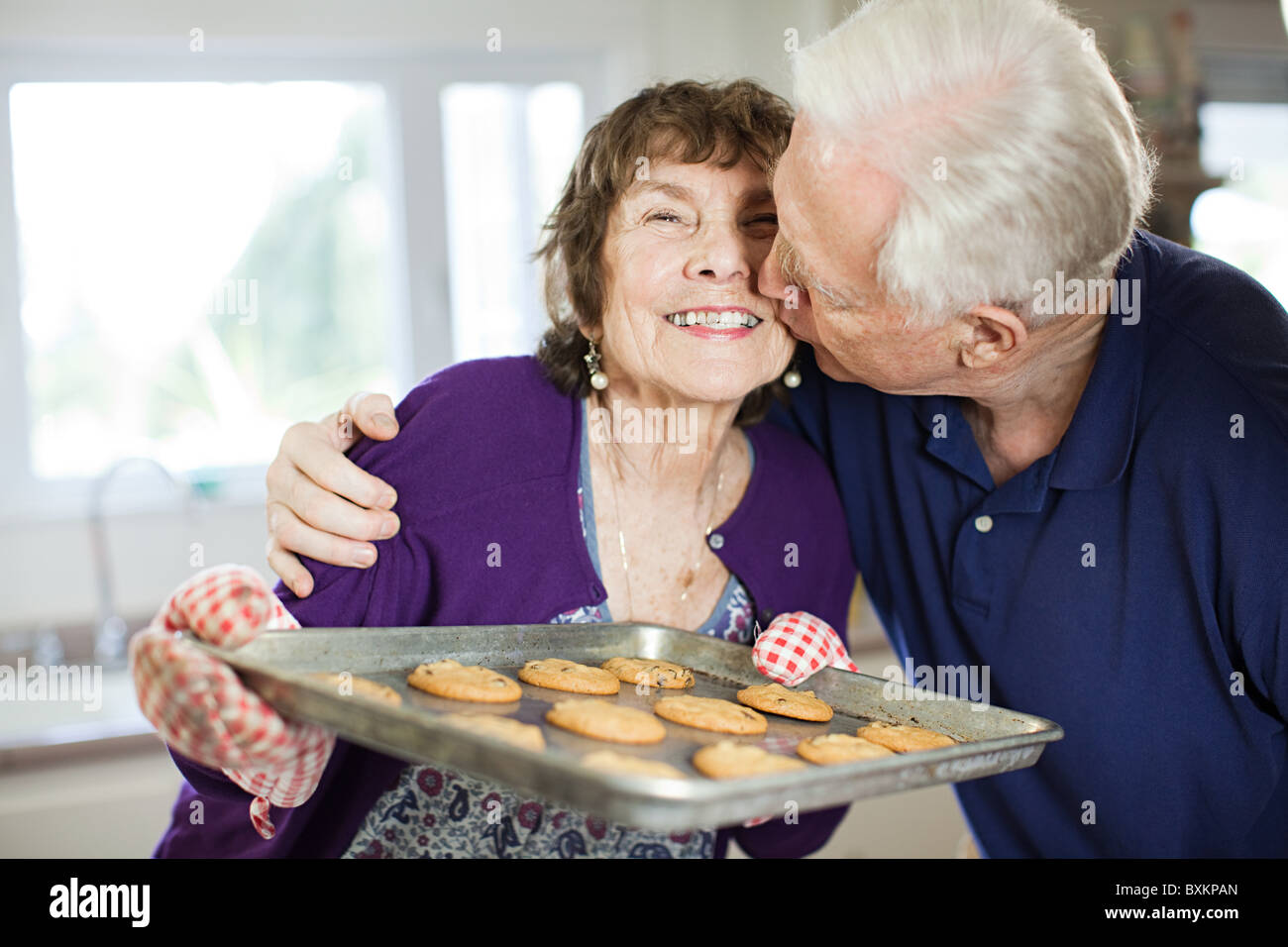 Coppia senior baciare con home biscotti Foto Stock