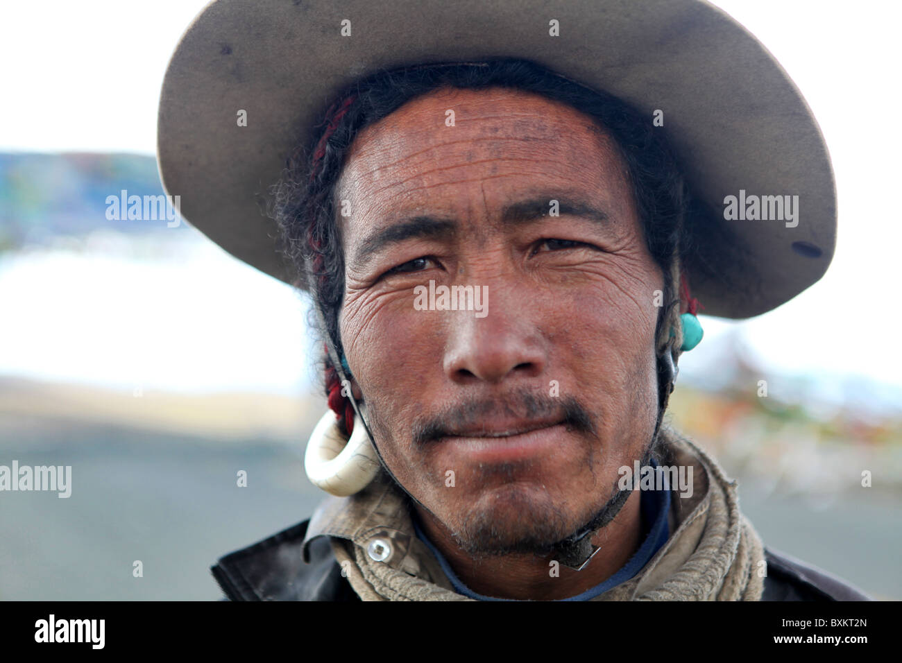 Un uomo tibetano in posa per una foto su un alta montagna passare sulla strada per il Campo Base Everest in Tibet, in Cina. Foto Stock