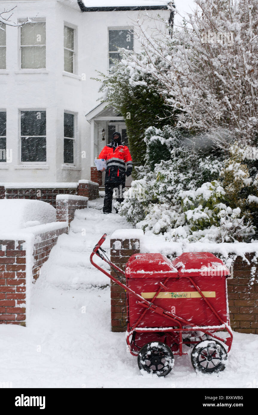 Un postino consegnare le lettere durante una tempesta di neve nel sud di Londra Foto Stock