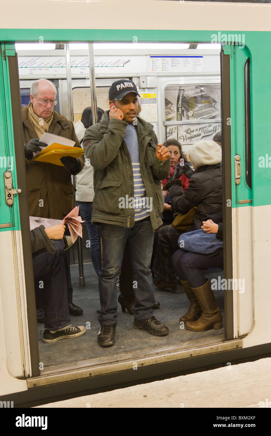 Il passeggero parlando al telefono cellulare in corrispondenza della porta di Parigi treno metro Foto Stock