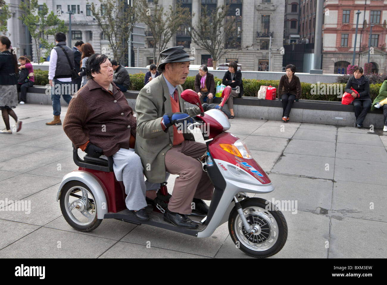 Coppia senior scooter di equitazione al Bund Promenade, Shanghai, Cina Foto Stock