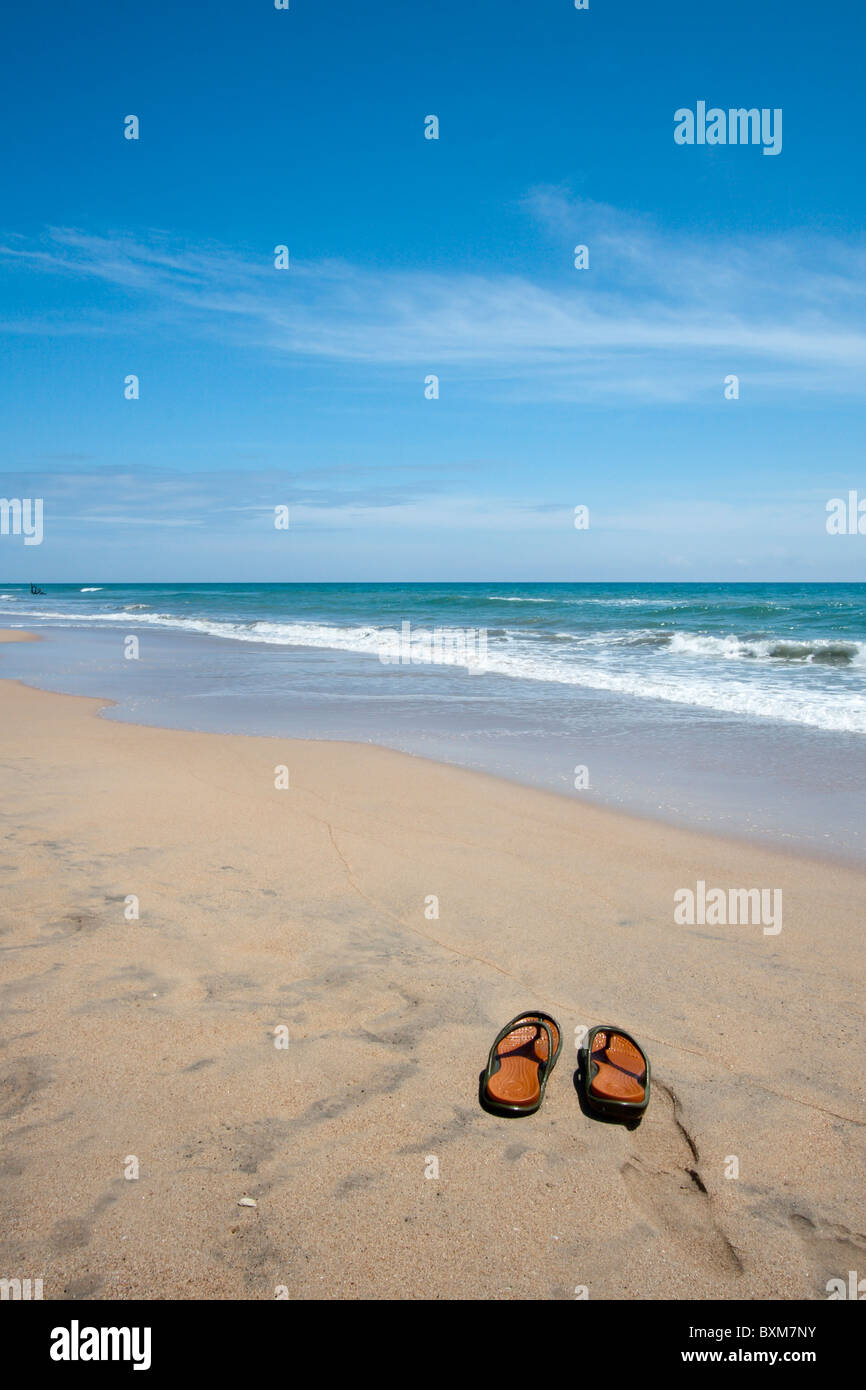 Paio di pantofole su una solitaria spiaggia di Nilaveli, Trincomalee, Sri Lanka East Coast. Foto Stock