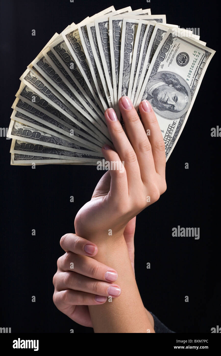 Le mani umane tenendo la ventola di un centinaio di banconote Foto Stock