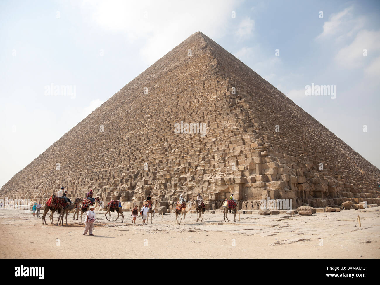 Intorno al grande piramide ci sono egiziani venditori di escursione a dorso di cammello. Foto Stock