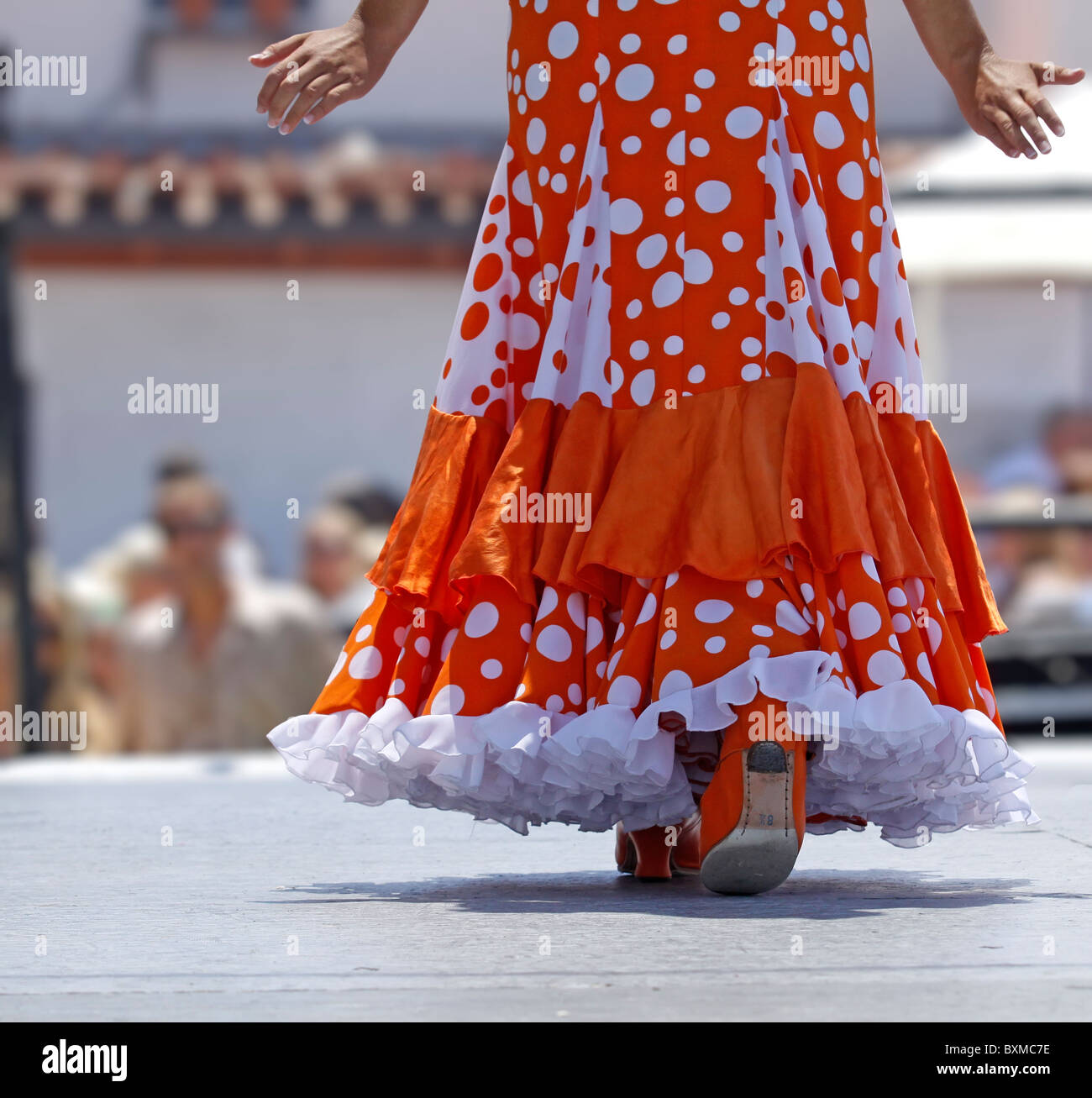 La ballerina di flamenco in un abito arancione camminando sul palco Foto Stock