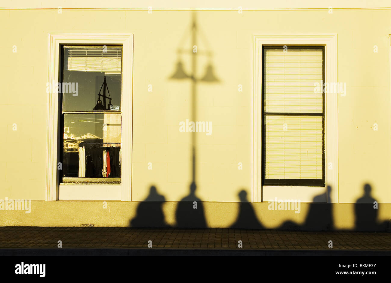 Ombre di turisti su una parete di un edificio sul lungomare, Queenstown, New Zealand Nuova Zelanda Foto Stock