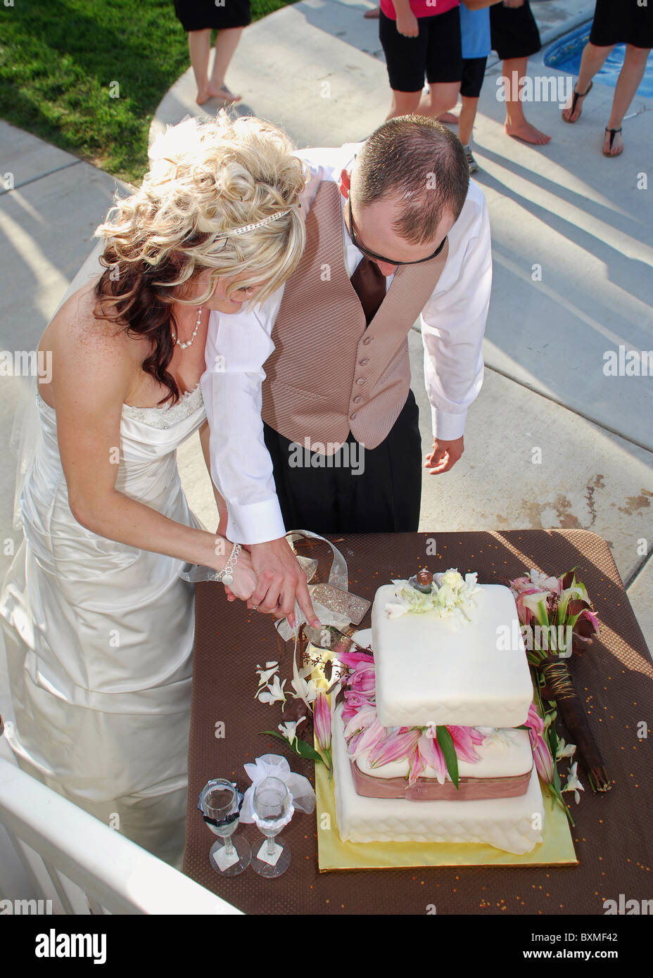 Giovane sposa e lo sposo il taglio di torta di nozze Foto Stock