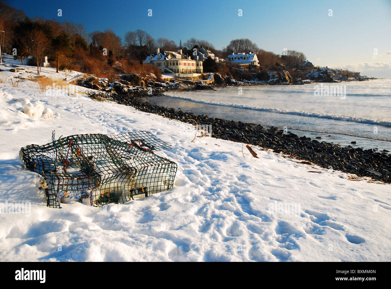 Un scartato lobster trap idolo si siede in inverno lungo una spiaggia deserta di York, Maine Foto Stock
