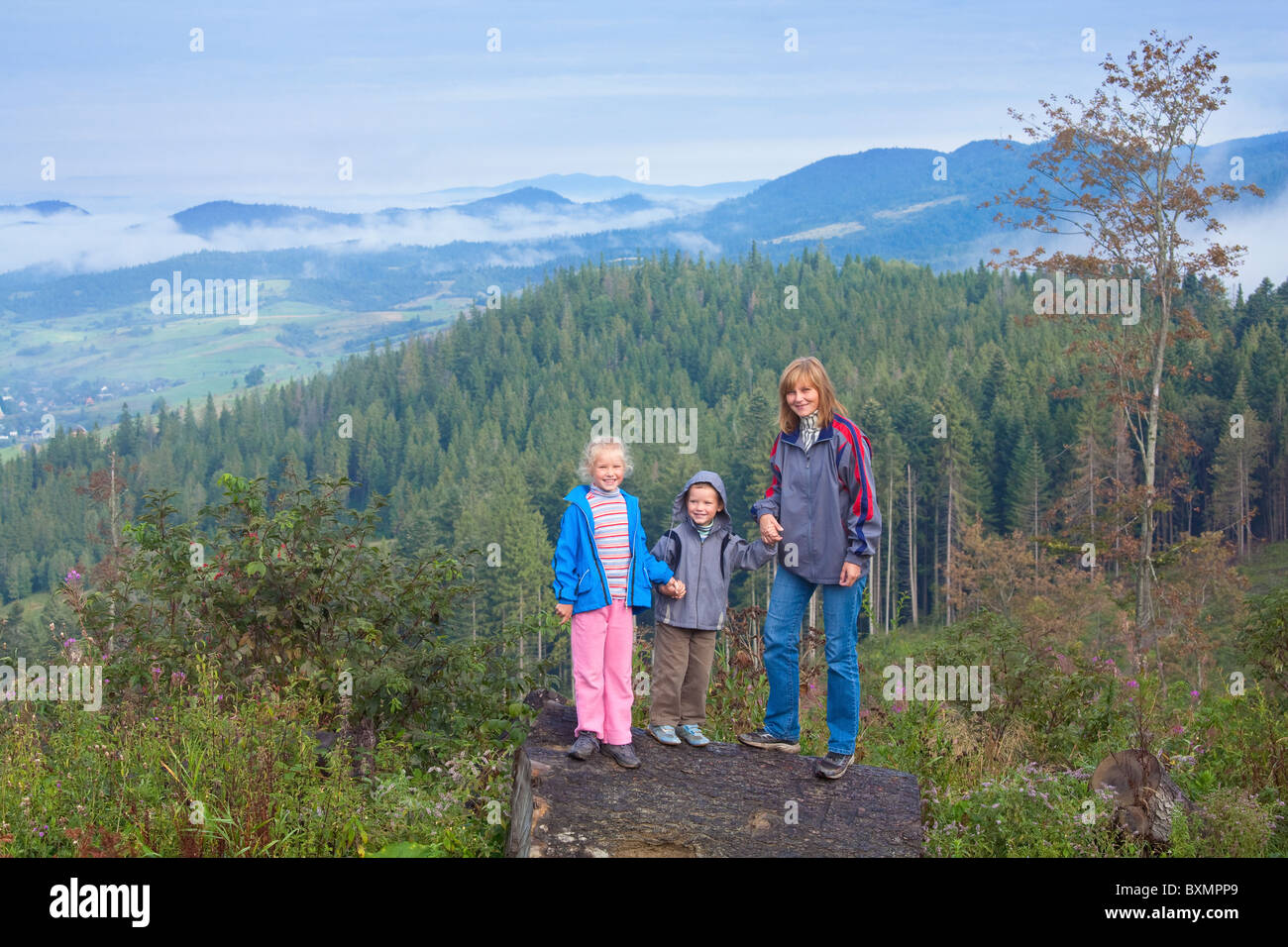 Famiglia su settembre montagna dei Carpazi hill e nuvoloso vista la mattina dietro Foto Stock