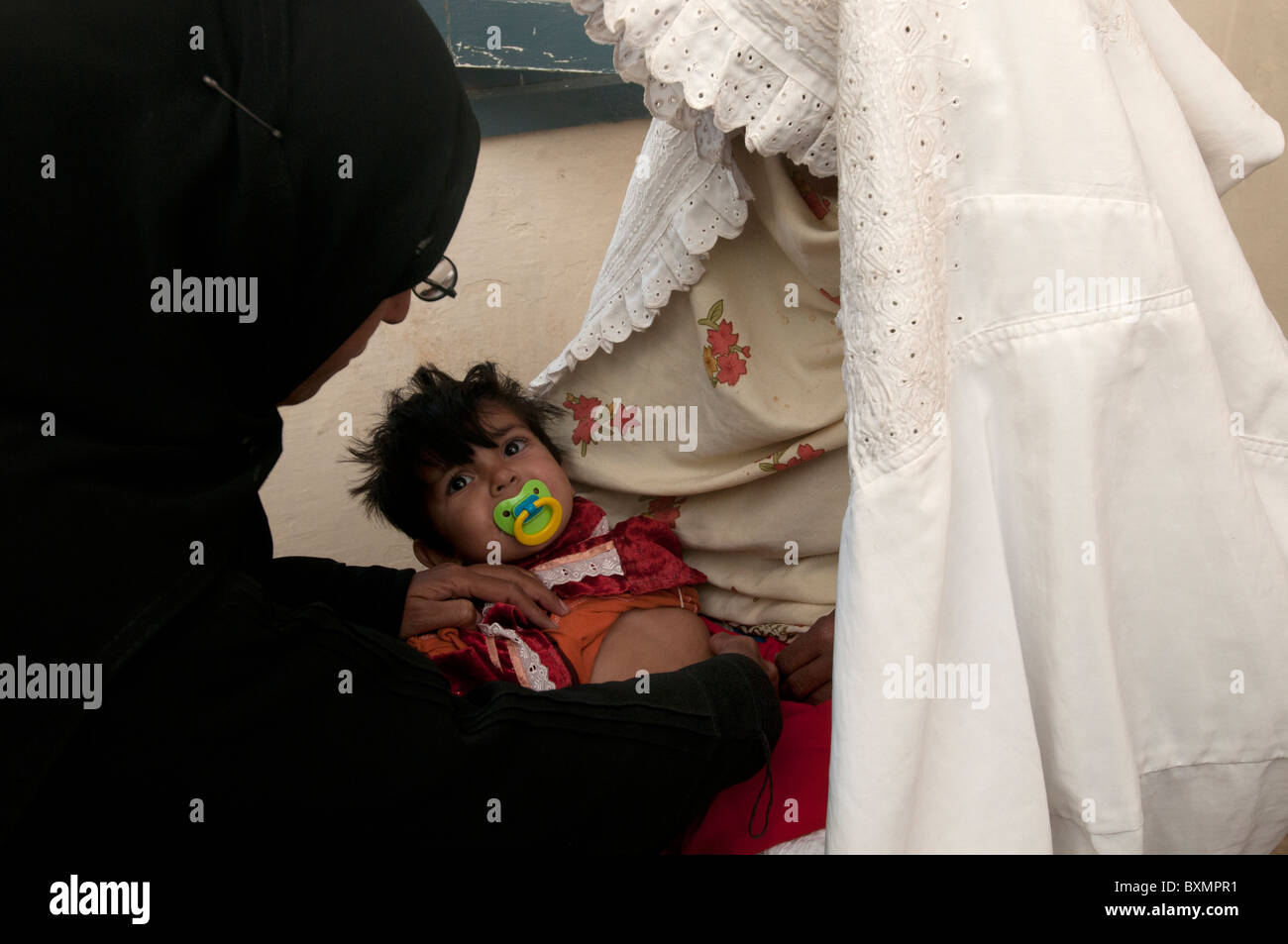 Il Pakistan dopo il diluvio. Pirsa Baq village.Dr Hasiba Oggi Tarin esamina 6 mese Sumaya vecchio che ha una infezione toracica Foto Stock