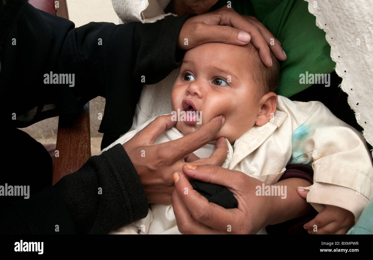 Il Pakistan dopo il diluvio.Dr Hasiba Oggi Tarin esamina baby Fakir Ahmed di età compresa tra i 8 mesi che ha un cattivo torace e un'infezione all'orecchio. Foto Stock