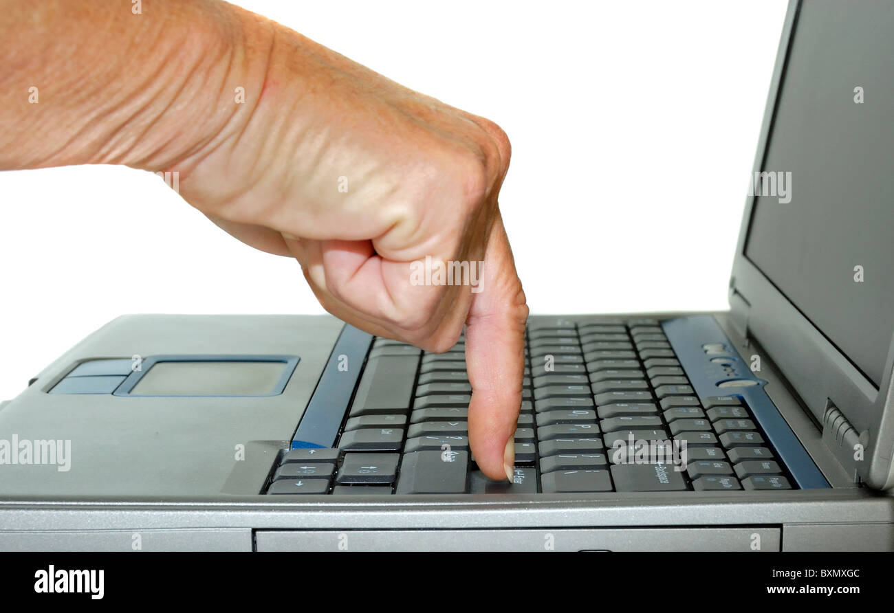 Un indice di una mano che colpisce il pulsante Invio su un computer portatile. Foto Stock