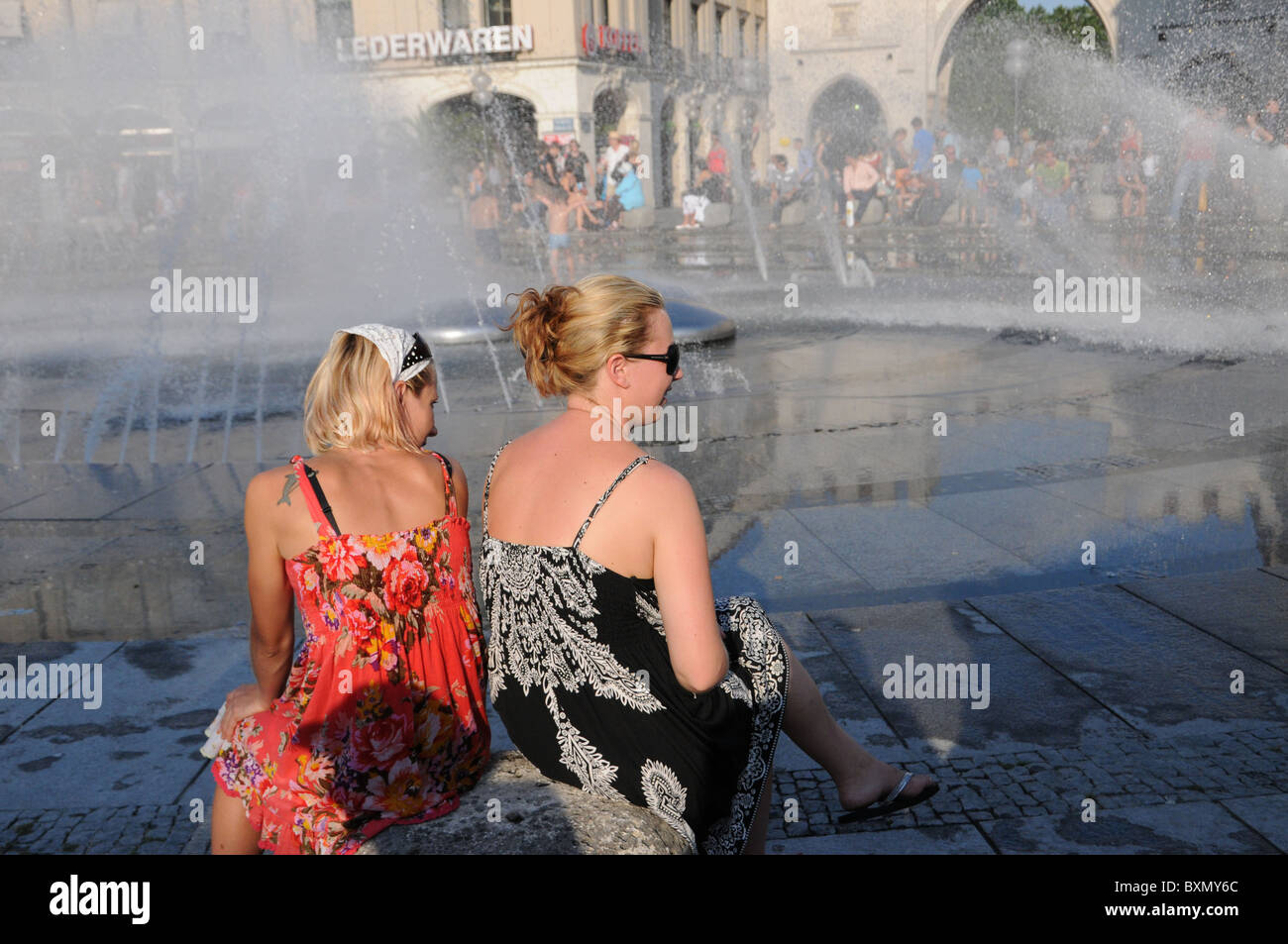 Due donna seduta a Karlsplatz Fountaine a Monaco di Baviera Foto Stock