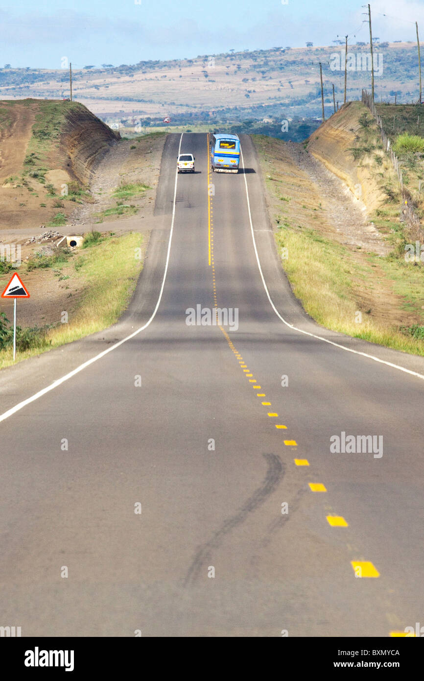 Il bus unsafely passando un minivan in Kenya, Africa orientale Foto Stock