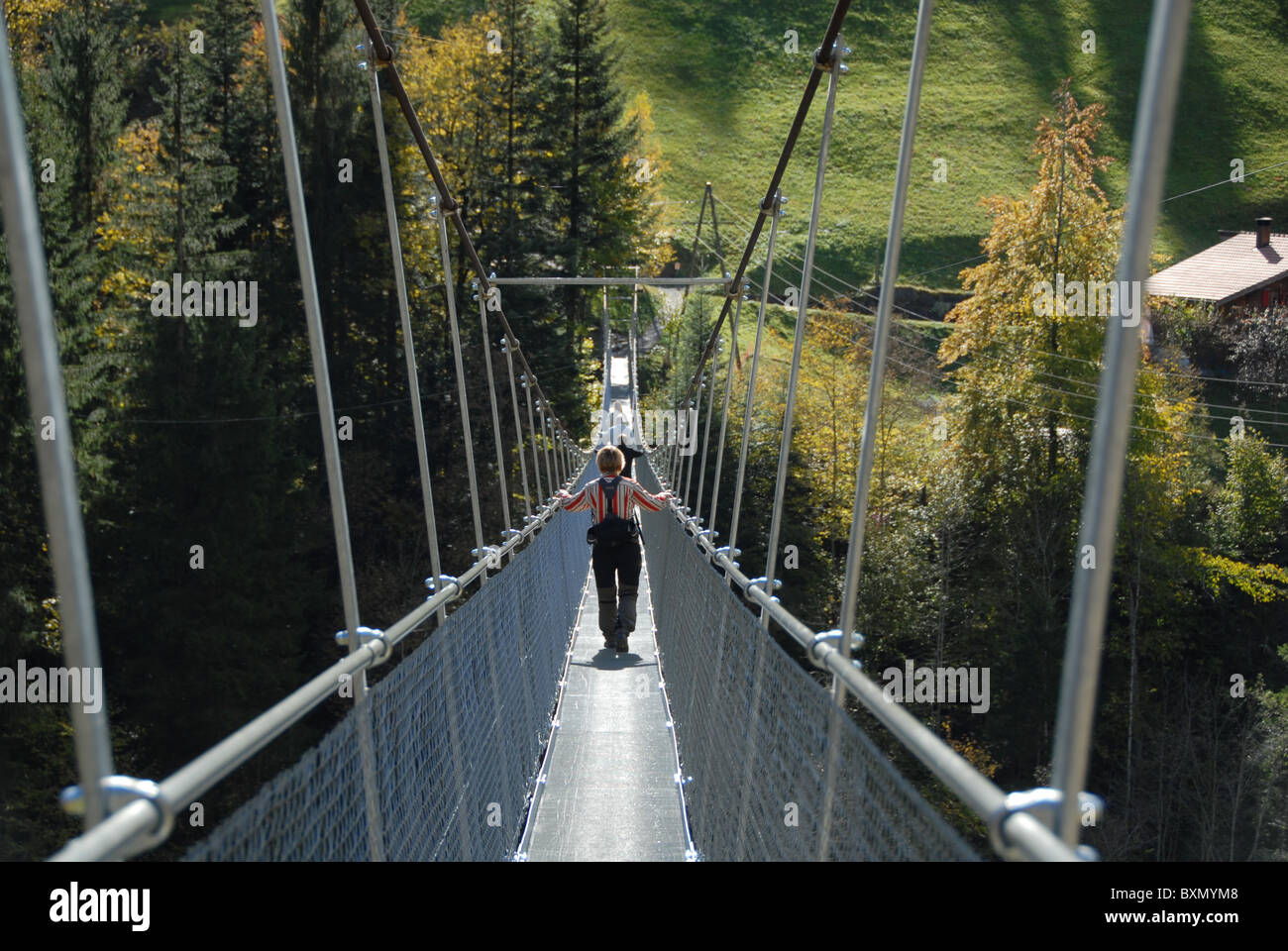 Le persone camminando sul Ponte sospeso oltre il fiume Engsligen, Frutigen, Oberland bernese, Svizzera Foto Stock