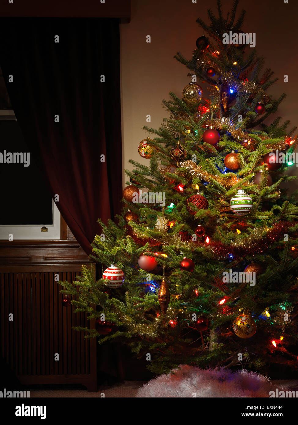 Albero di Natale decorato in ambienti chiusi di notte con le sue luci su Foto Stock