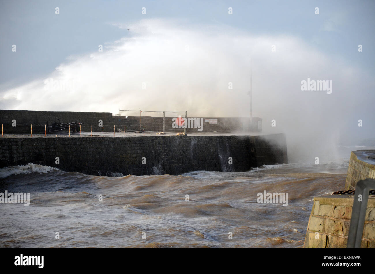 Onde di una grande tempesta batte il porto di Aberaeron in un freddo dicembre mattina quale è un rifugio sicuro per imbarcazioni Foto Stock