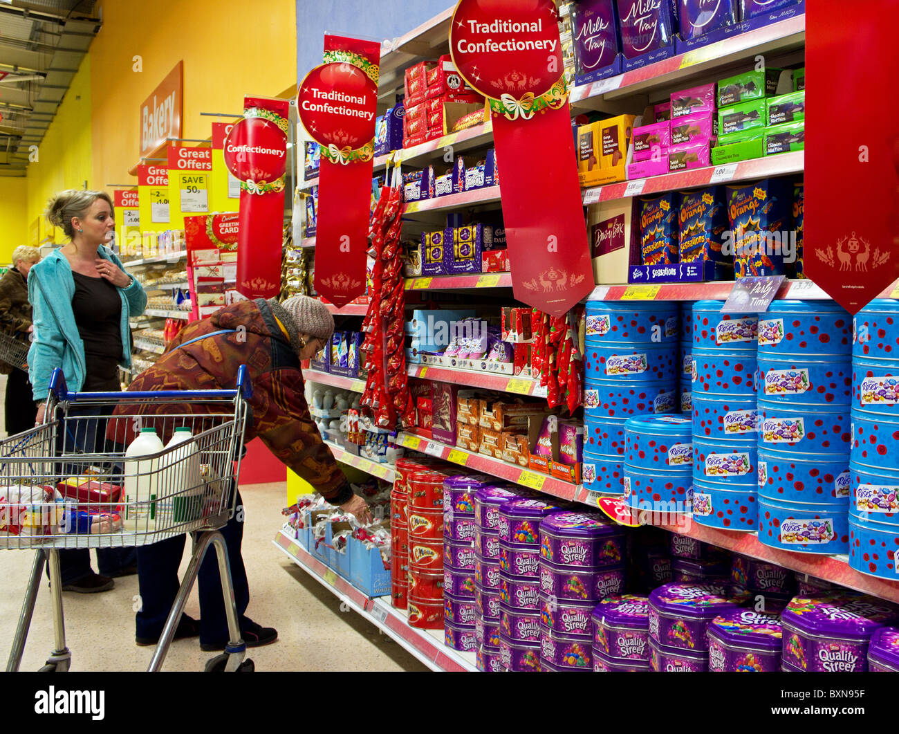I clienti che comprano dolci di natale in un supermercato Tesco, Regno Unito Foto Stock