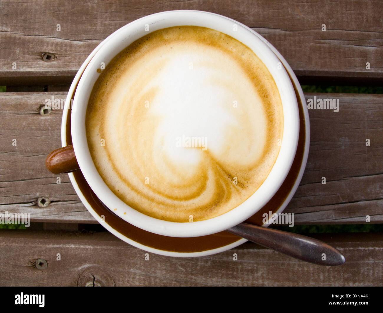 Un modello è stato disegnato in schiuma sulla parte superiore di questo piatto bianco caffè Foto Stock