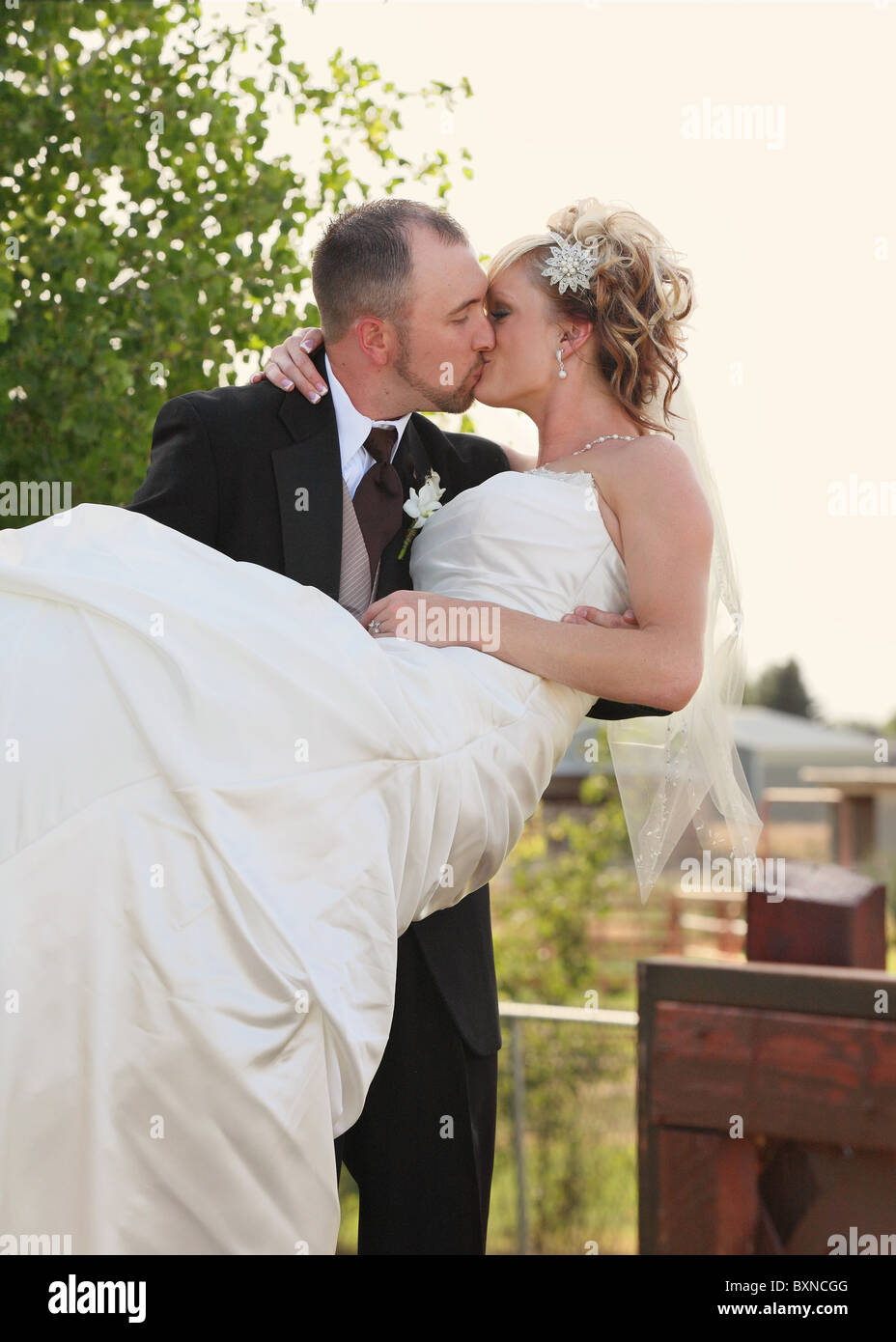 Attraente giovane sposa giovane all'aperto kissing Foto Stock