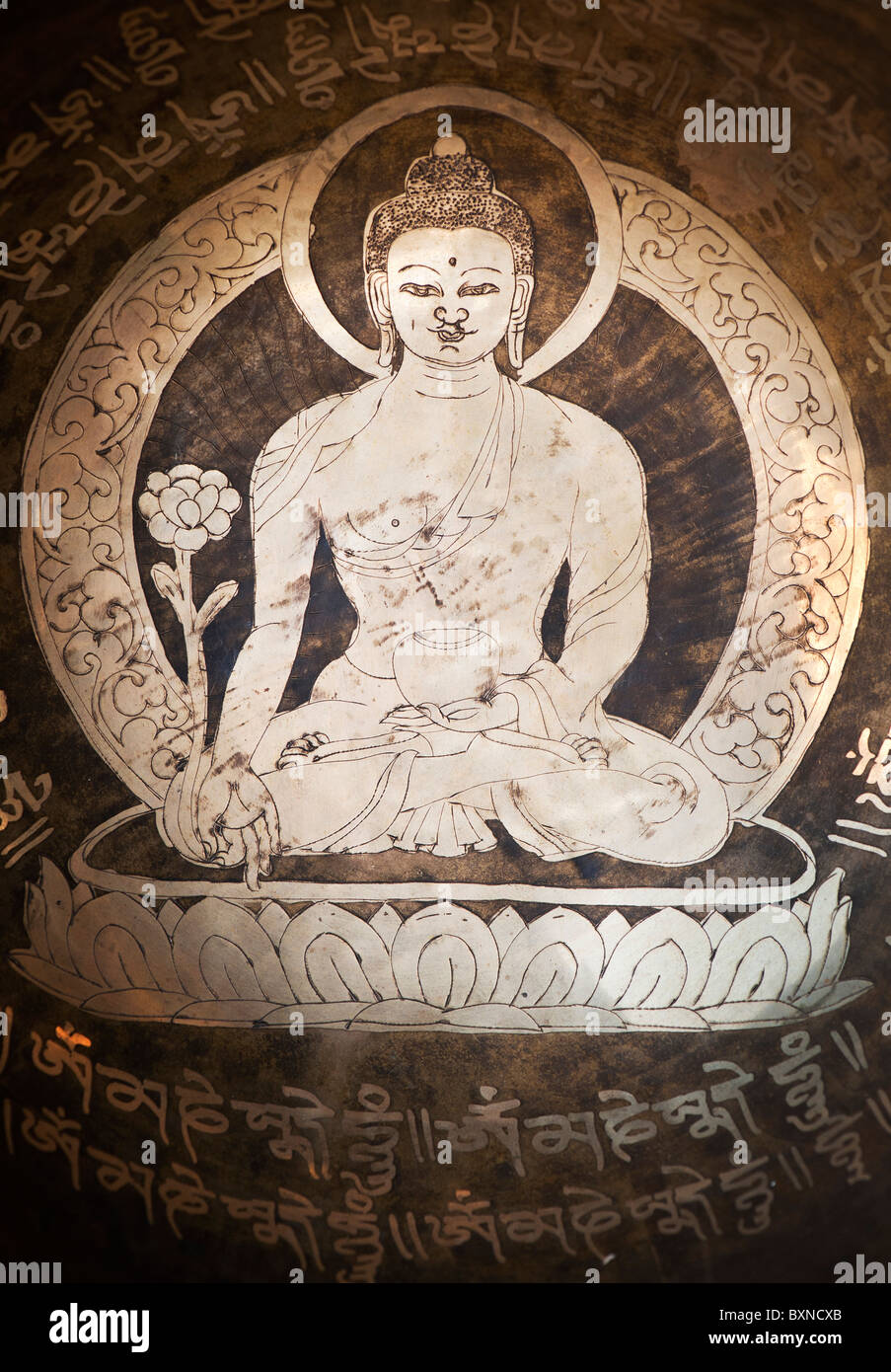 Buddha inciso nel mezzo di un tibetano Singing Bowl. India Foto Stock