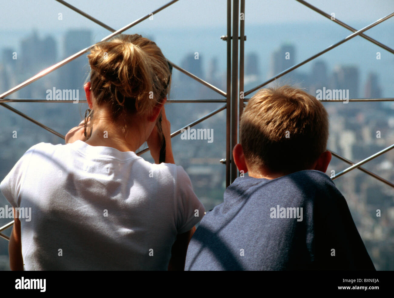 Due figli adolescenti guardando lo skyline di New York dalla piattaforma di visualizzazione nella parte superiore dell' Empire State Building Foto Stock