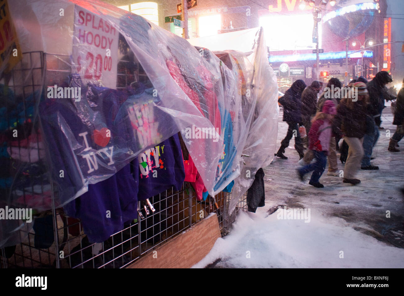 I Newyorkesi e visitatori di manovra attraverso la neve in Times Square a New York Foto Stock