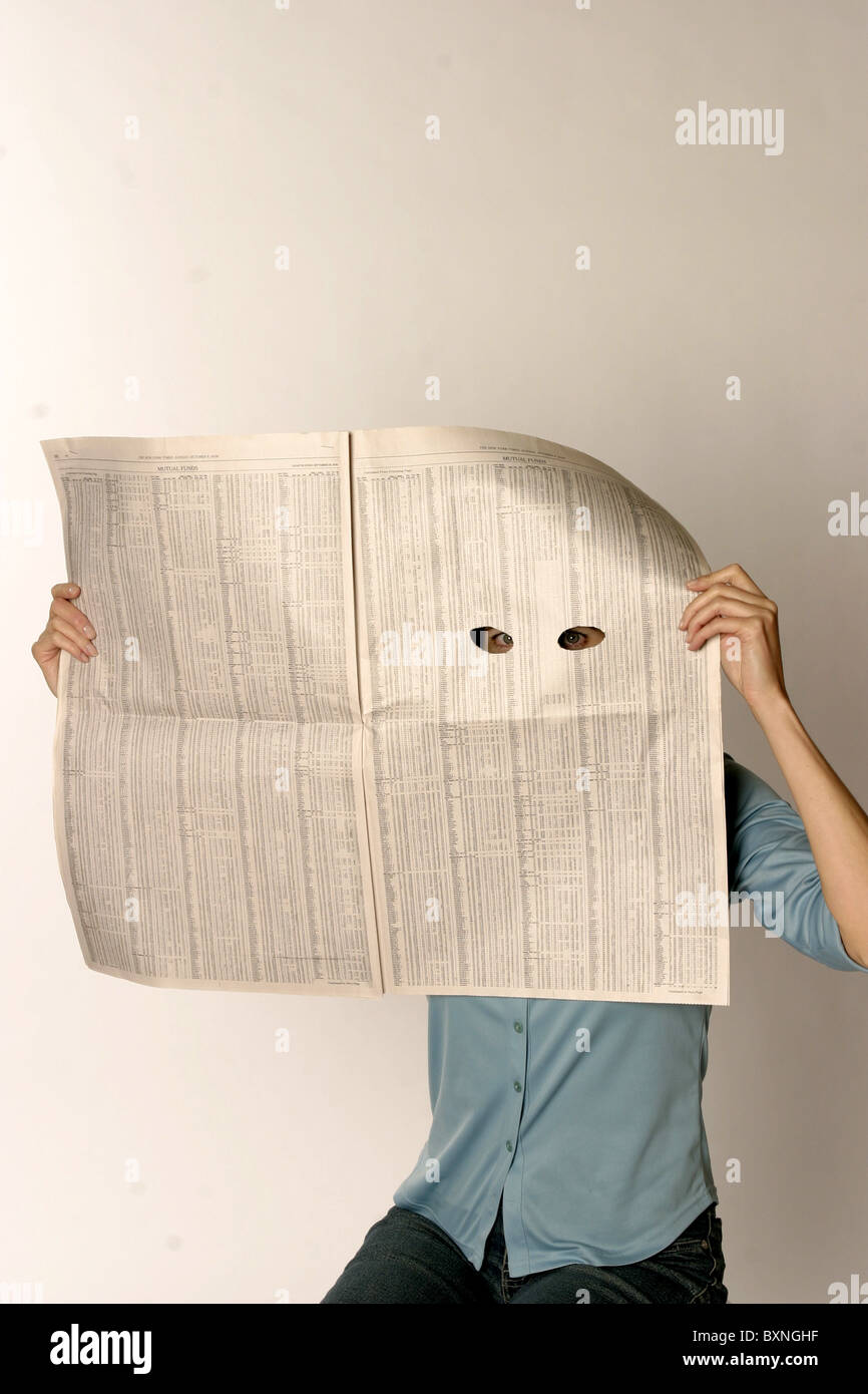 Una persona fa capolino attraverso eueholes in un giornale, spionaggio, surveilance Foto Stock