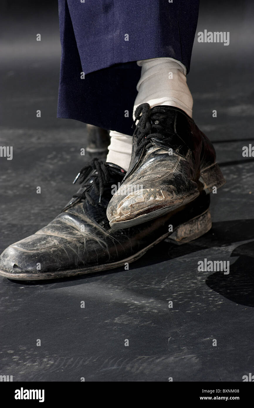 Close up dei piedi di un uomo che indossa il vecchio martoriato nero scarpe  in pelle Foto stock - Alamy