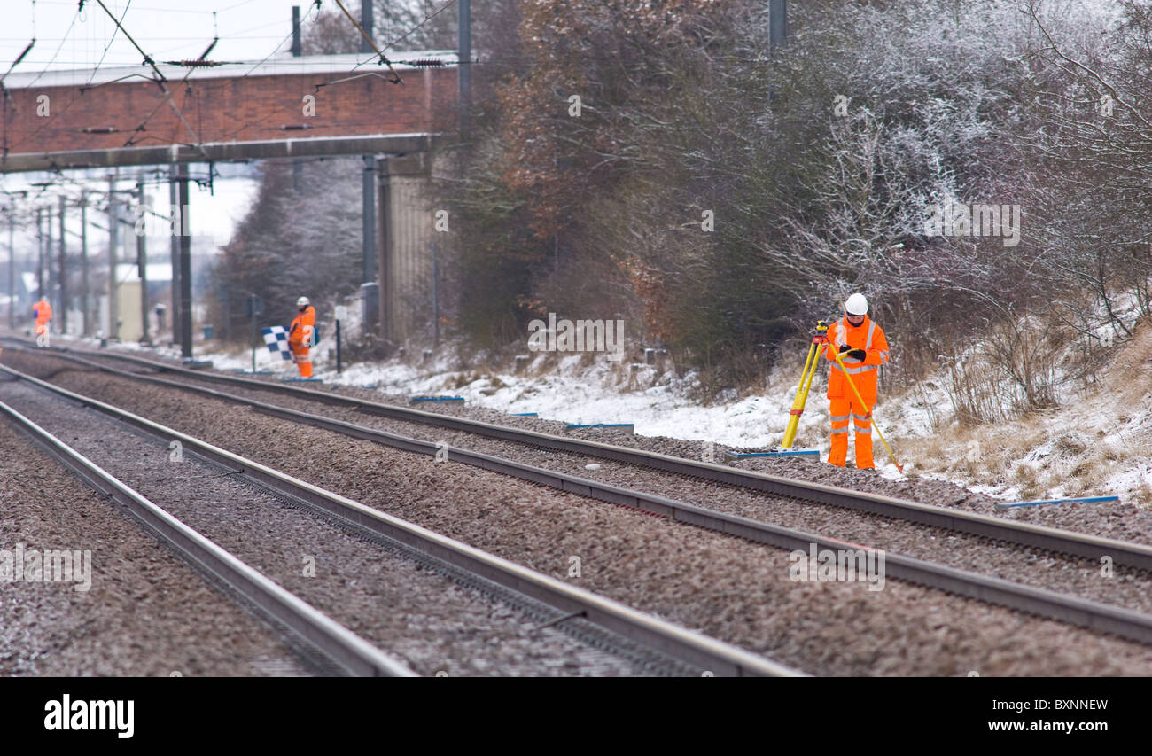 Lavoratori ferroviari il rilevamento della via lungo la costa est mainline indossare i loro indumenti ad elevata visibilità per la sicurezza. Foto Stock