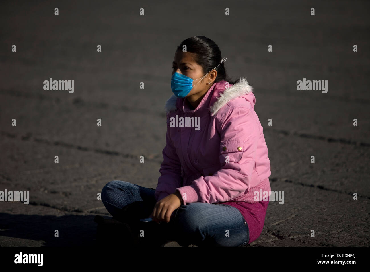 Una giovane donna che indossa una maschera come precauzione contro l influenza suina si trova a Città del Messico la principale piazza Zocalo, 1 maggio 2009. Foto Stock