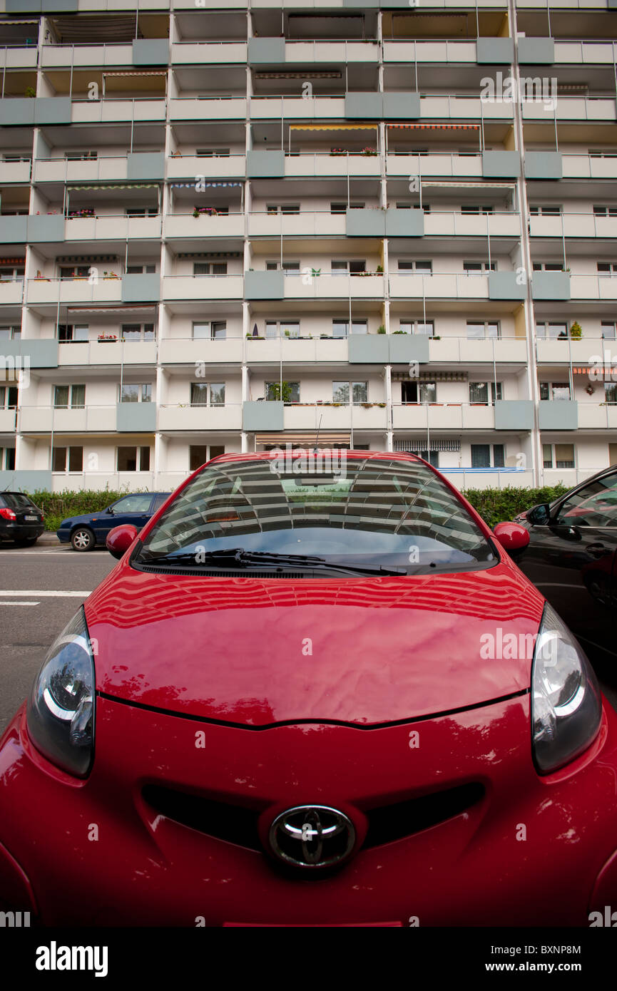 Auto rossa nella parte anteriore dei blocchi di appartamenti a Lipsia, in Sassonia, Germania, Europa Foto Stock